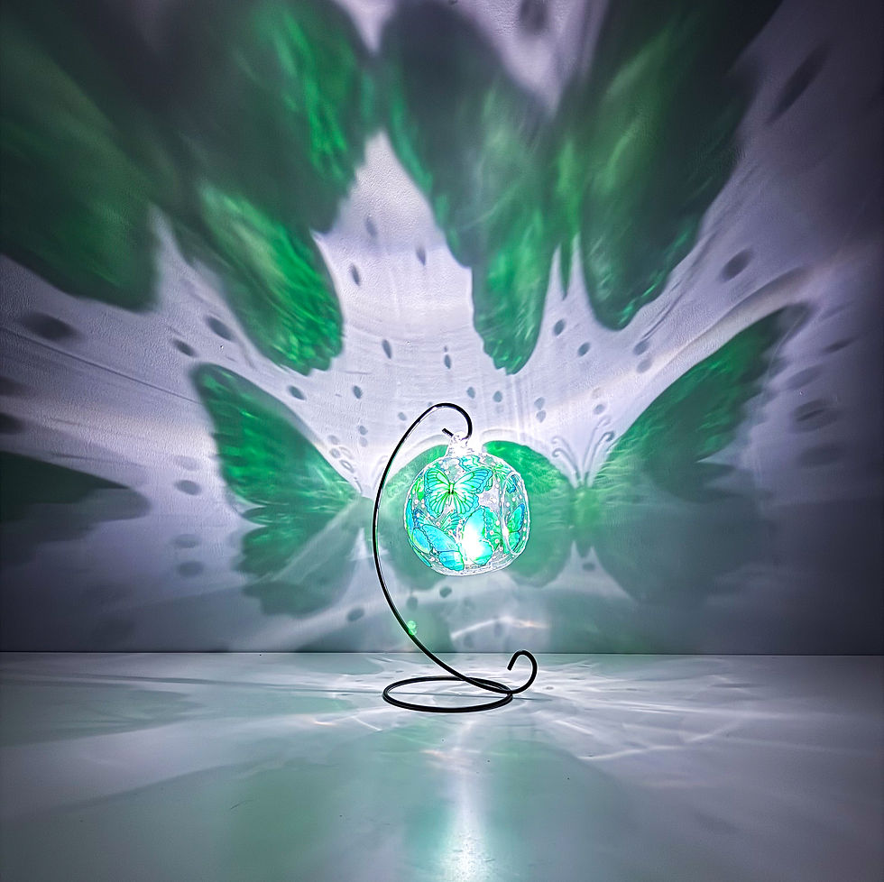 Hand-painted green glass butterfly ornament illuminated by a tealight to showcase its decorative light and shadow effects