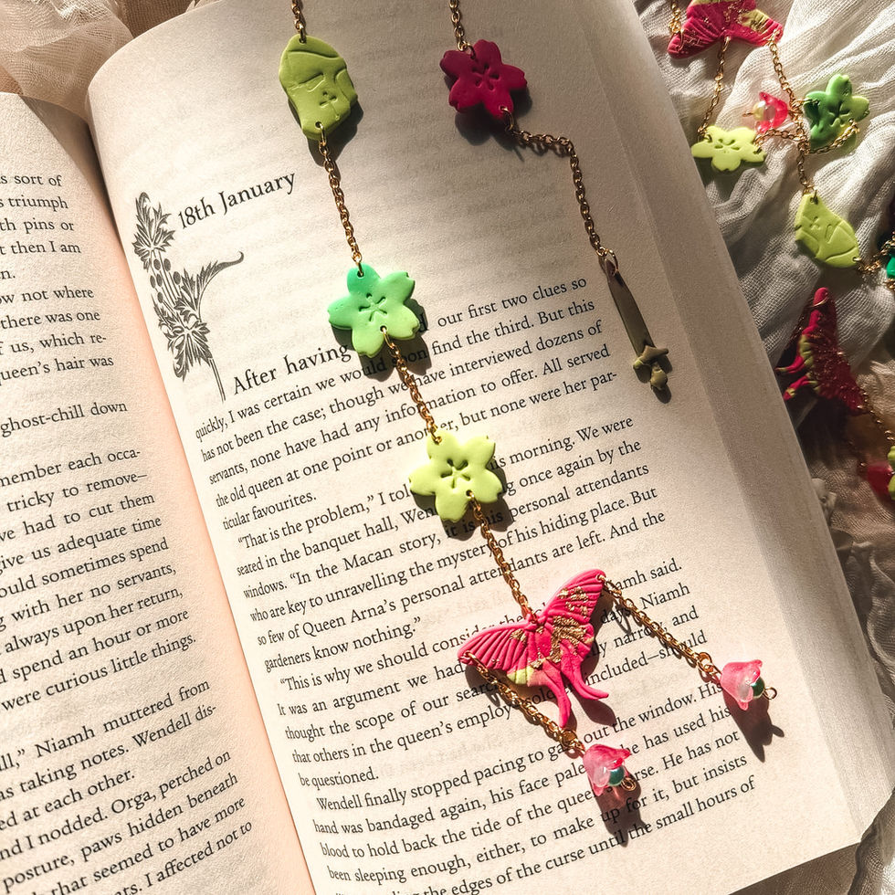 Rainbow Moonlit Wing bookmarks laid on top of an open book
