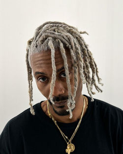 Man with long blonde dreadlocks and dark roots