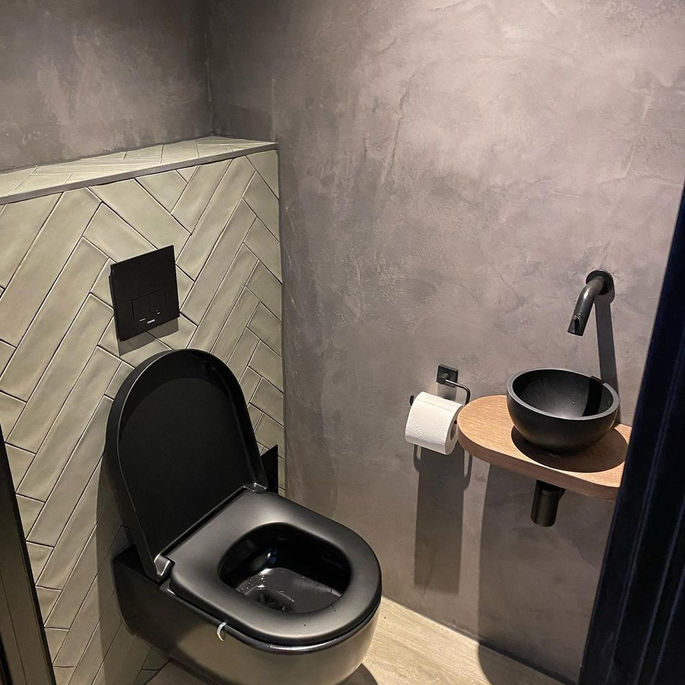 Toilet met betoncire en visgraat tegels