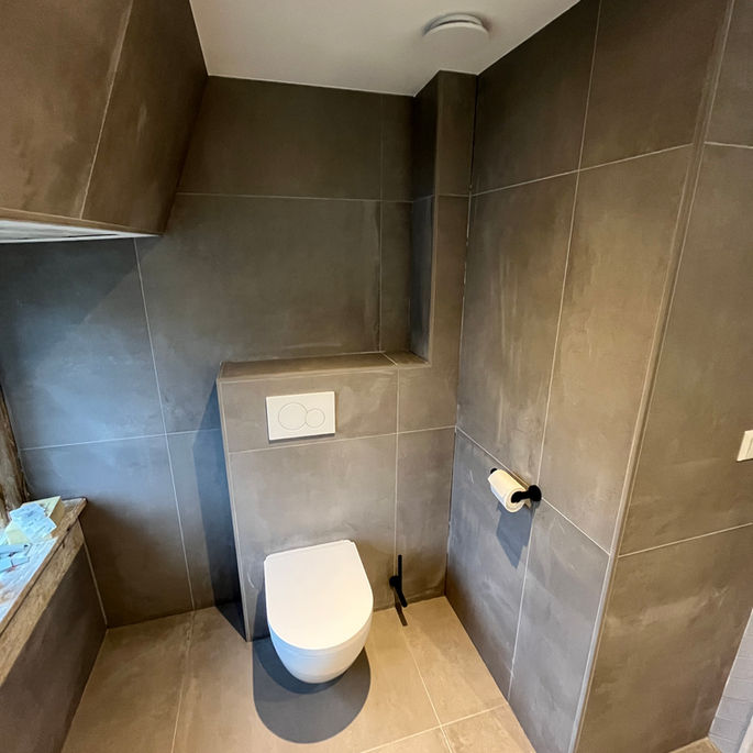 Badkamer met schuine wand en grootformaat tegels