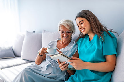 Happy patient is holding caregiver for a hand while spending time together. Professional h