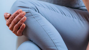 Woman over 50 holding her knee due to joint pain that moves around during perimenopause