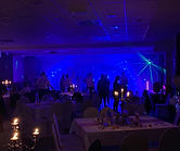Party Gäste im blauen DJ Licht, davor luxuriös gedeckte Tische