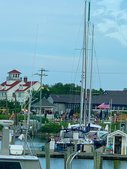 Boat dock and shore in Sandwich, MA, busy with boats and people