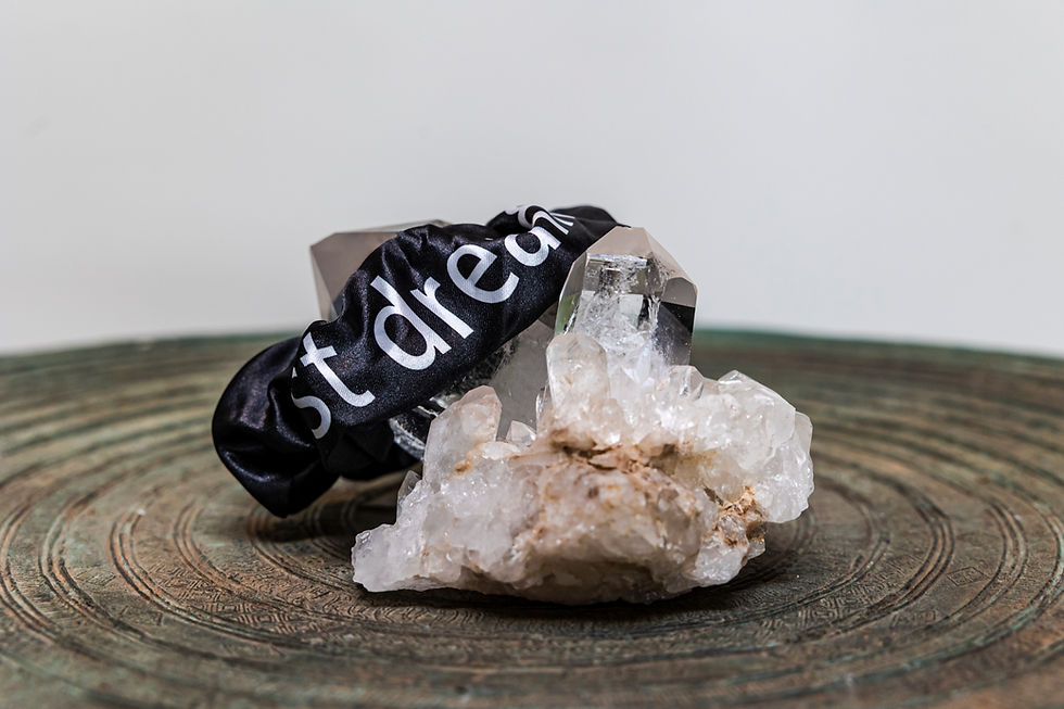 Thumbnail: Black "Just Dream" affirming message hair scrunchie resting on a crystal