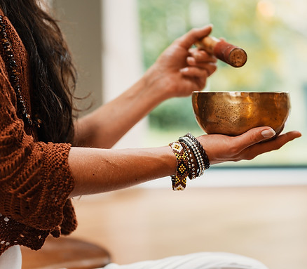 woman in brown knit sweater holding brow