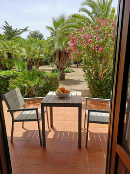 Veranda con mobili da esterno e vista giardino a Villa dei gabbiani Favignana per una colazione romantica all'aperto 