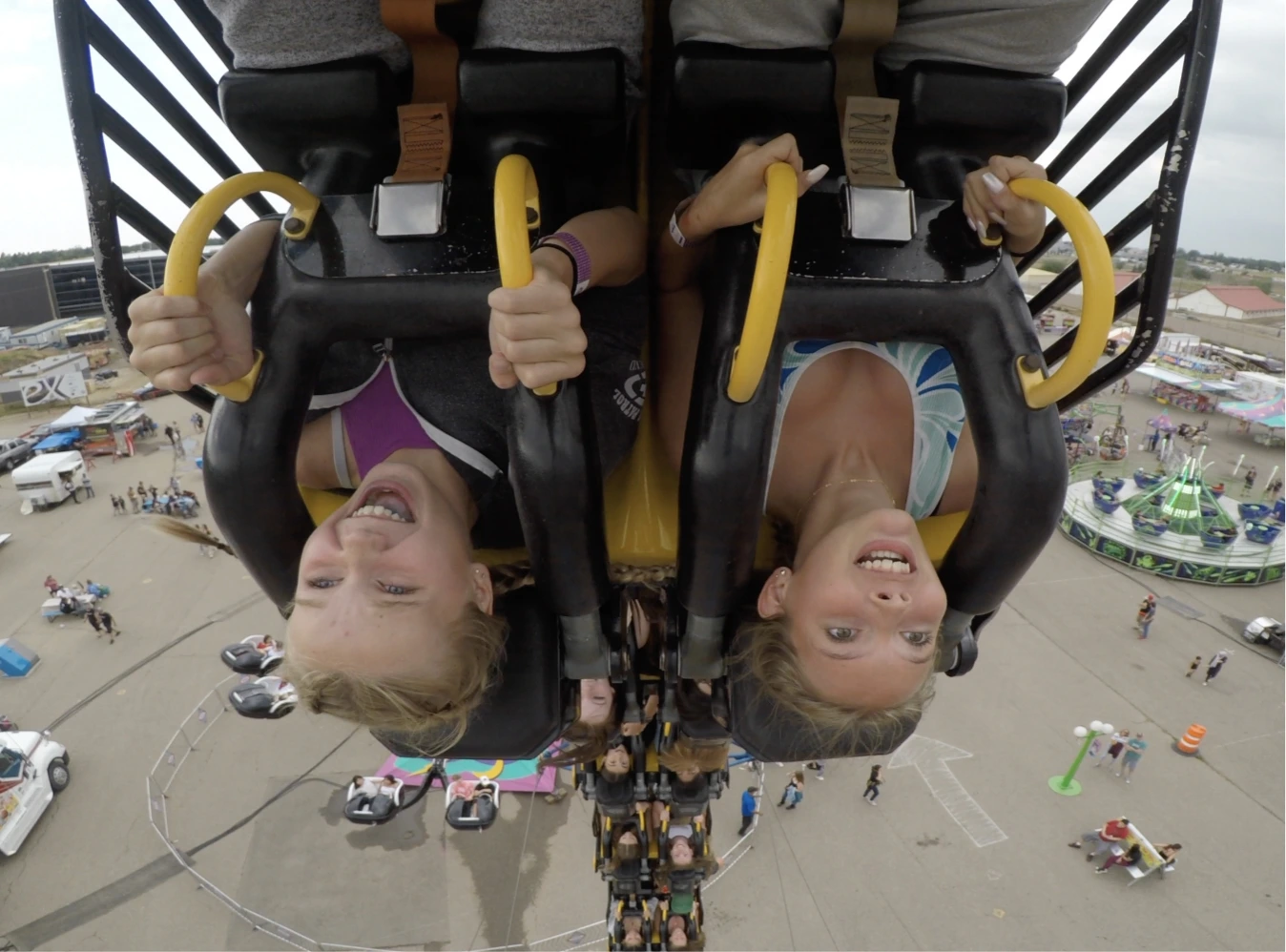 two kids upside down on a carnival ride