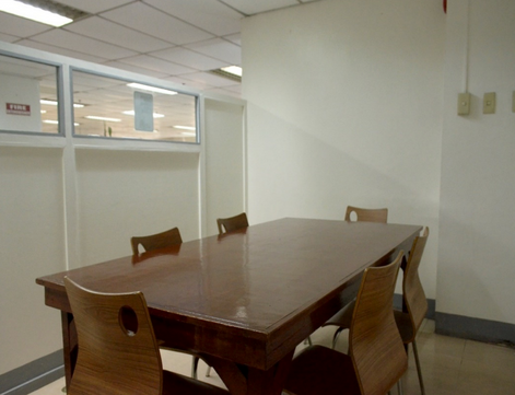 Group study space with white plastic chairs and orange table in a learning discussion room