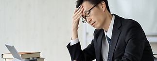Worried asian businessman holding his head.jpg