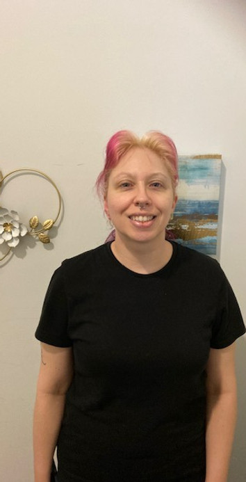 Rachel, Massage Therapist at A Touch of Serenity in Alexandria, VA, smiling in a black shirt. Rachel specializes in Swedish, deep tissue, and hot stone massage with a focus on stress management and relaxation. She has been with the team since 2024.