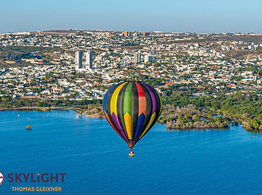 Colorful hot air balloon over a lake and city