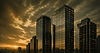 Tall buildings against a dramatic sunset sky