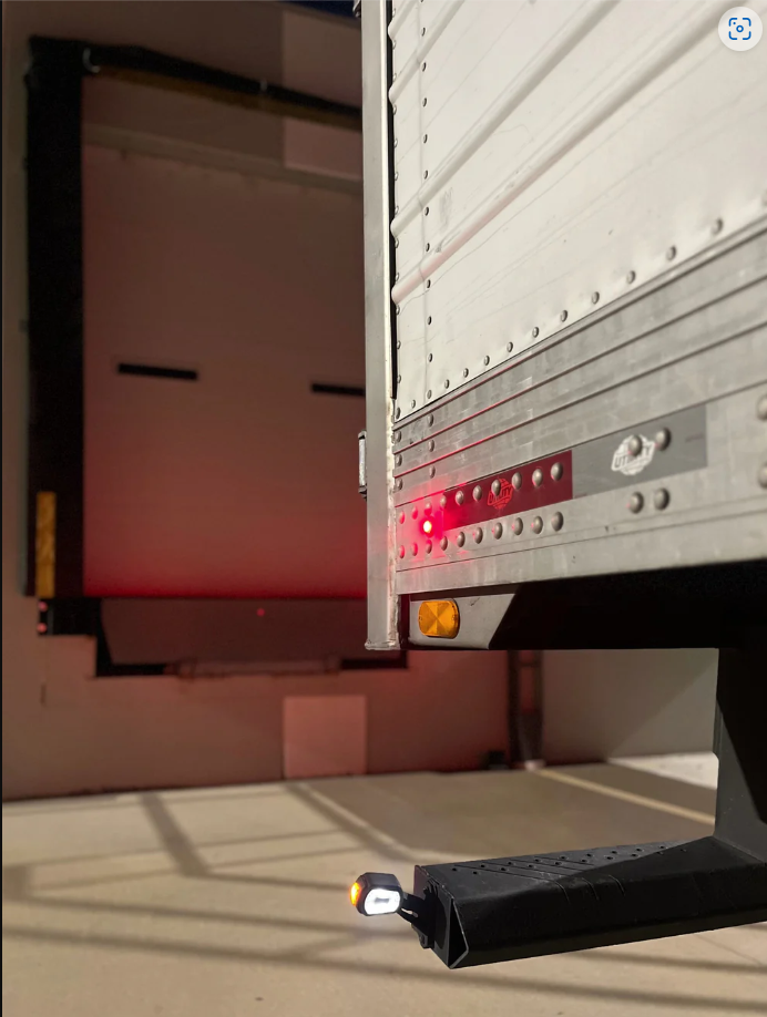 Roadlites outline marker light installed on trailer bumper shining brightly in a dock door. 
