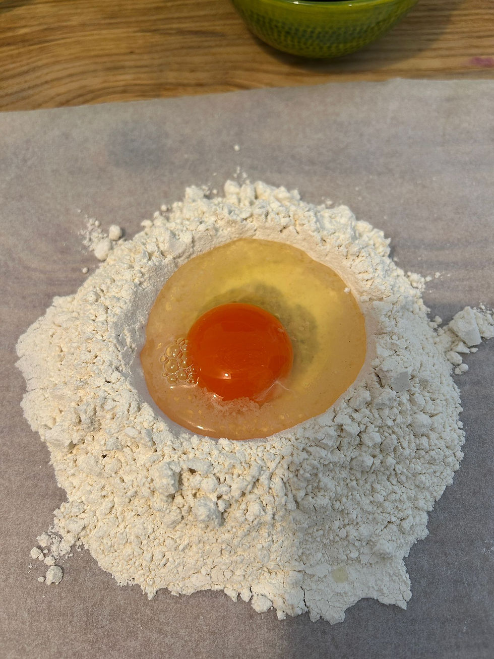 Raw egg in a well of flour on a table