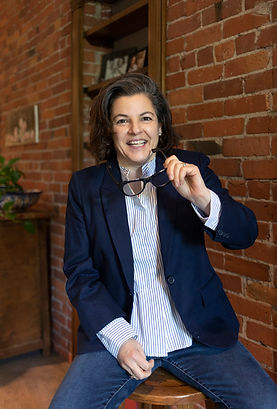 Photo of Denise Brodey Creator of Spike in Blue Jacket against a brick walll