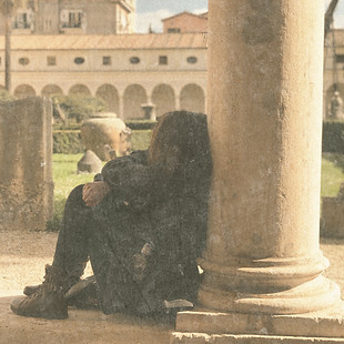author sitting against a pillar