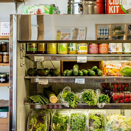 Fresh produce and prepared foods in a refrigerated display case.