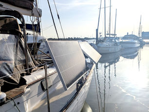 DIY boat solar panel installation mounted on stainless rail system on a sailboat in a UK marina