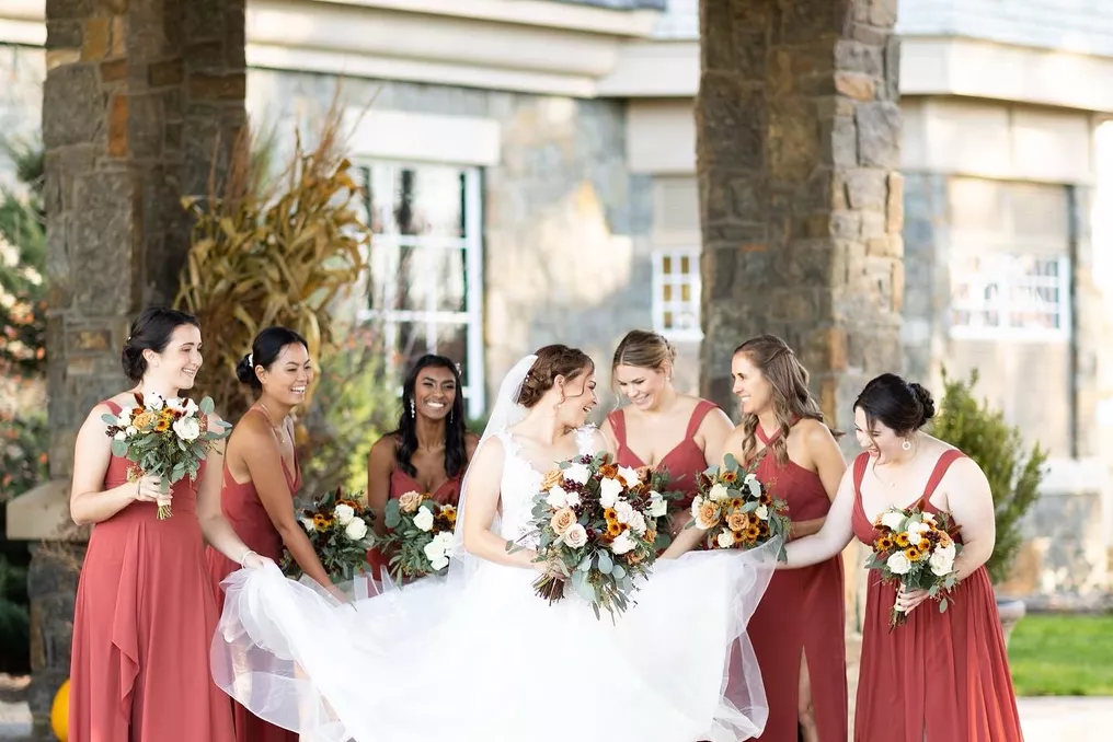 Bride and Bridesmaids in burnt orange dresses and sunflower bouquets