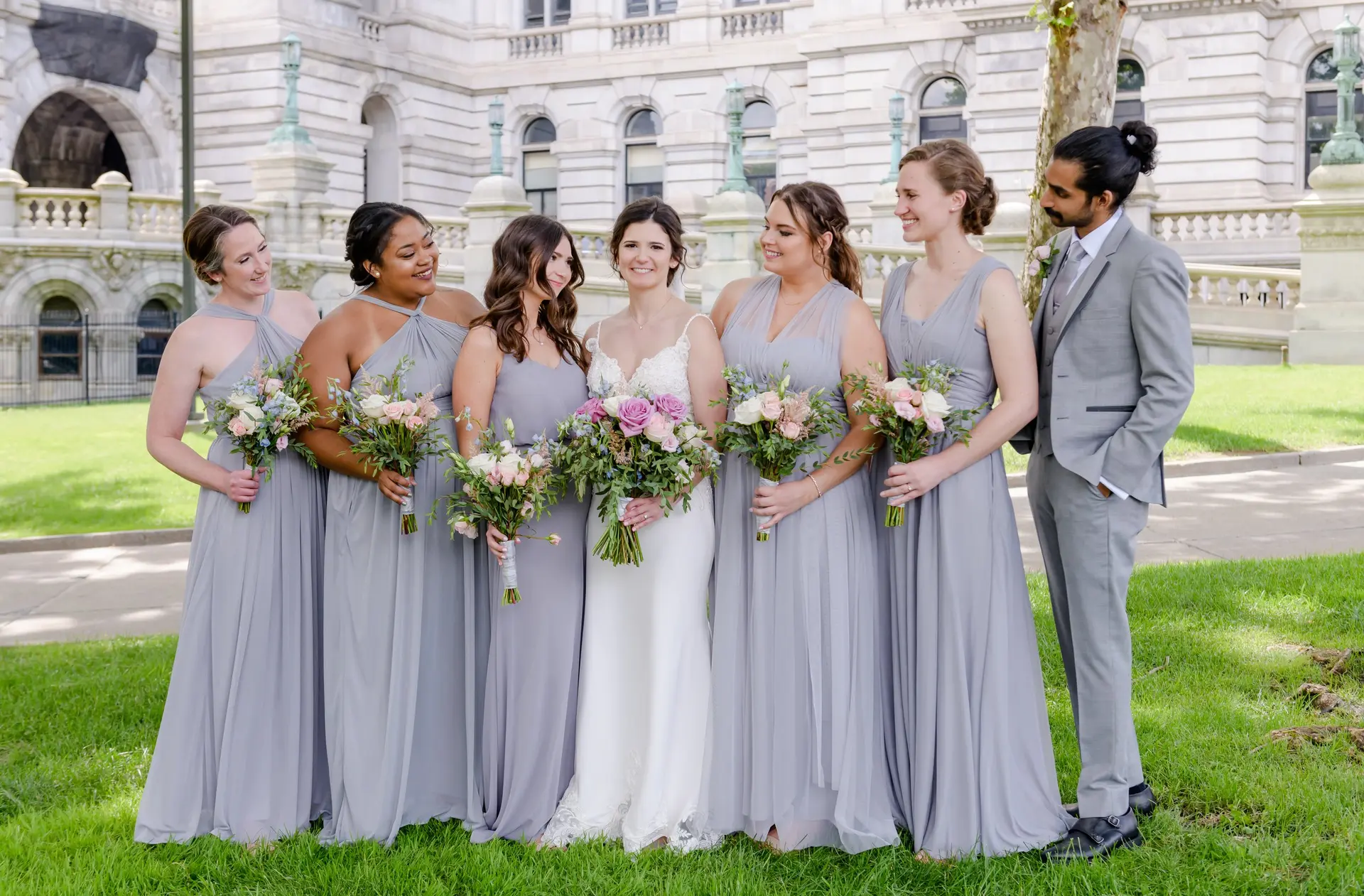 Bride and bridesmaids in gray dresses with wedding bouquets