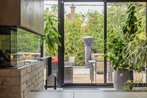 Vue traversante de l’intérieur vers terrasse et jardin paysager