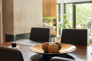 Décoration de table avec centre de table doré, cheminée en béton et grande baie vitrée – Projet Montligeon