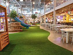 Área de juegos en food court utilizando grama artificial Grasspro Arcadia