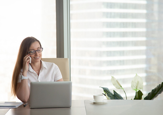 jeune-femme-d'affaires-souriant-parlant-au-téléphone-lieu-de-travail-communication-mobile-échelle_modifiée.jpg