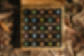 Top-down view of essential oil bottles in wooden storage box with colorful cap stickers.jp
