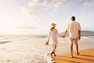 Couple walking on beach at sunset