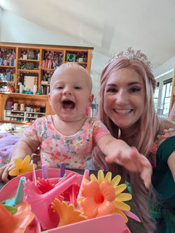 Happy baby and magical garden fairy character at birthday party