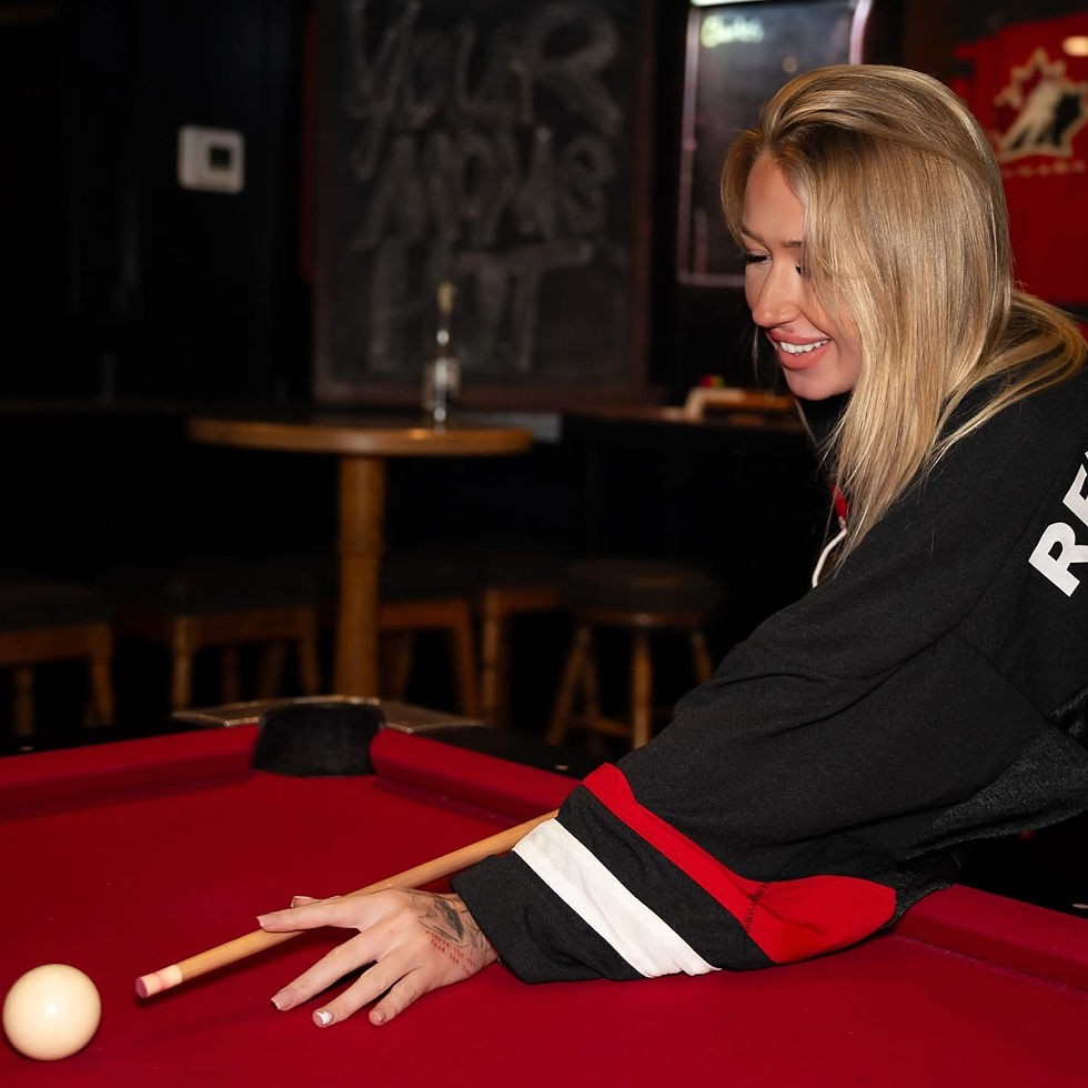 Guest playing pool on the red billiards table at Rendezvous Pub, Langley’s local hangout.