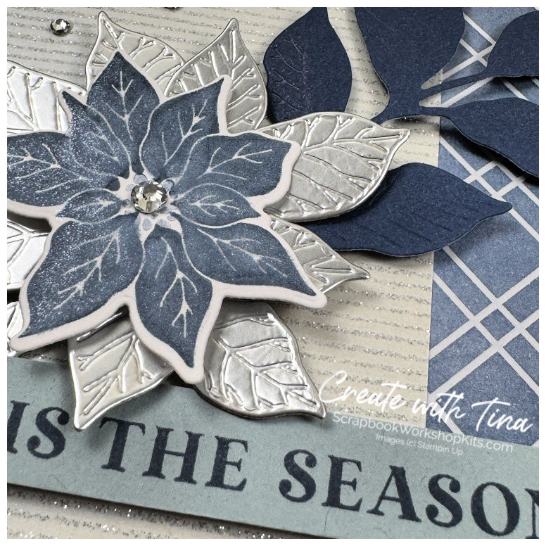Detailed navy poinsettia layered over embossed silver foil leaves, shimmering paper and blue plaid DSP.