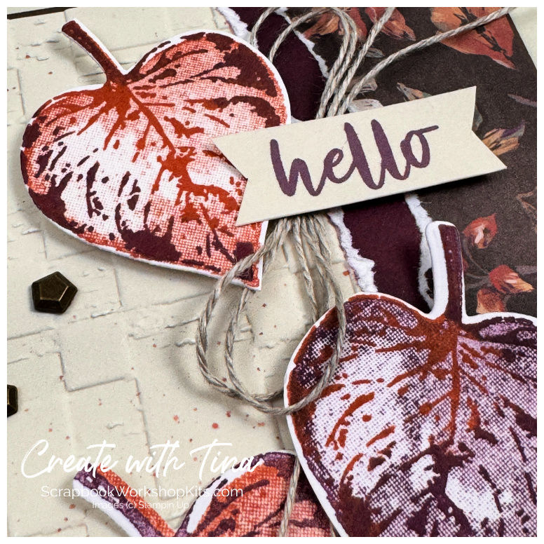 Close-up of stamped fall leaves in Cajun Craze and Blackberry Bliss with linen thread and a “hello” sentiment