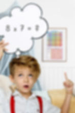 Junge mit Rechenaufgabe in Gedankenblase – Poster „Das kleine 1x1“ hängt im Hintergrund an der Wand.