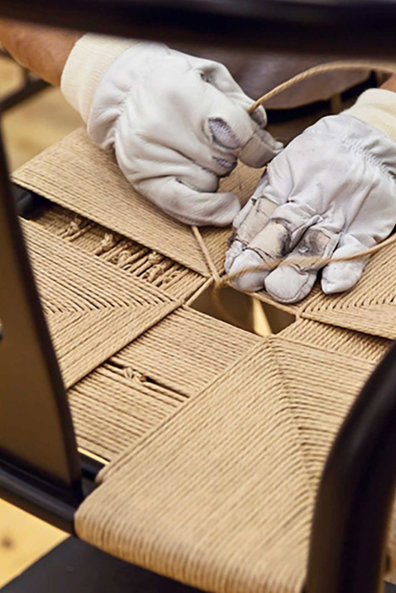 Craftsperson hand-weaving a natural fibre danish cord seat