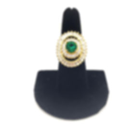 Green center crystal surronded by clear crystal stones in oval gold tone frame