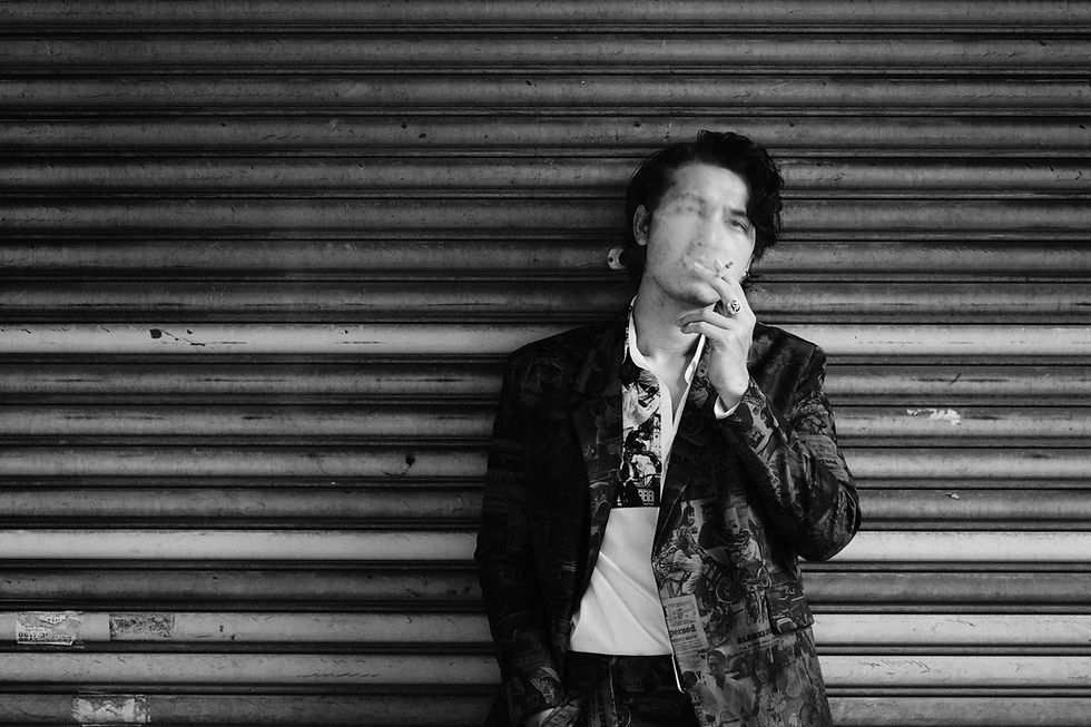 Homme qui fume adossé au mur