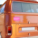 Pink bumper sticker with text "Bought the car not the cult" on a van