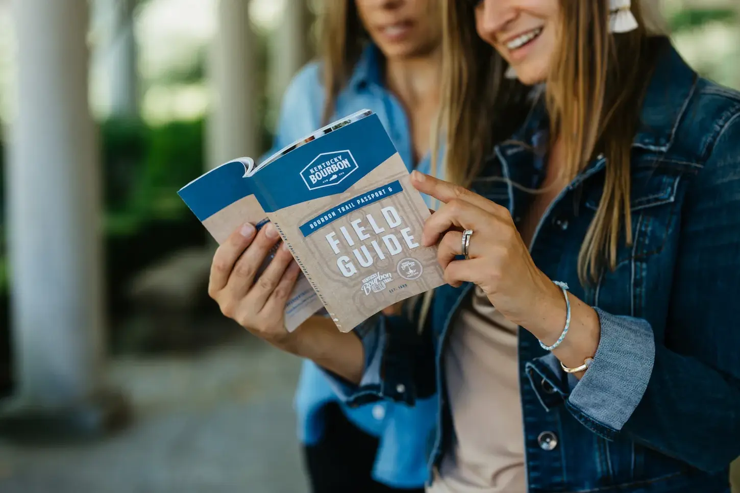 Women looking at the Kentucky Bourbon Field Guide booklet together