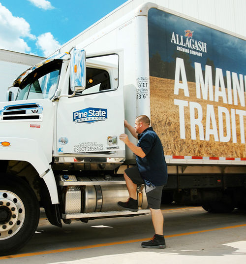 Pine State Beverage Beer Delivery driver stepping up into his truck to deliver Allagash beer to the local retail stores