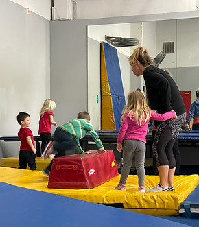 Young athletes with coach in a line waiting to get on a trampoline