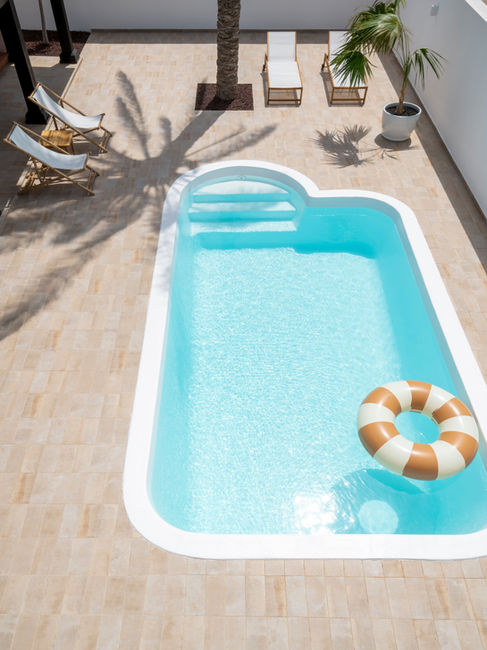 Muebles de terraza, fotografia de interiores, tumbonas, espacio al aire libre. Villa de Diseño con Piscina de estilo nordico en Corralejo, Fuerteventura. Proyecto de reforma y diseño de interiores por Noogar.