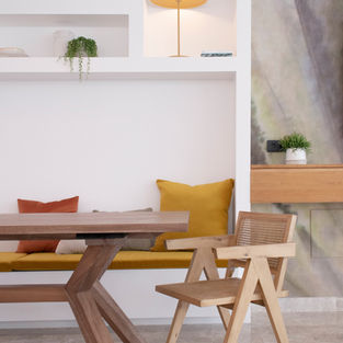 Villa in Corralejo - Fuerteventura. Built-in furniture with a bench, seating pads and colourful cushions, designed by Noogar. Dining room with contemporary wooden table and chairs.