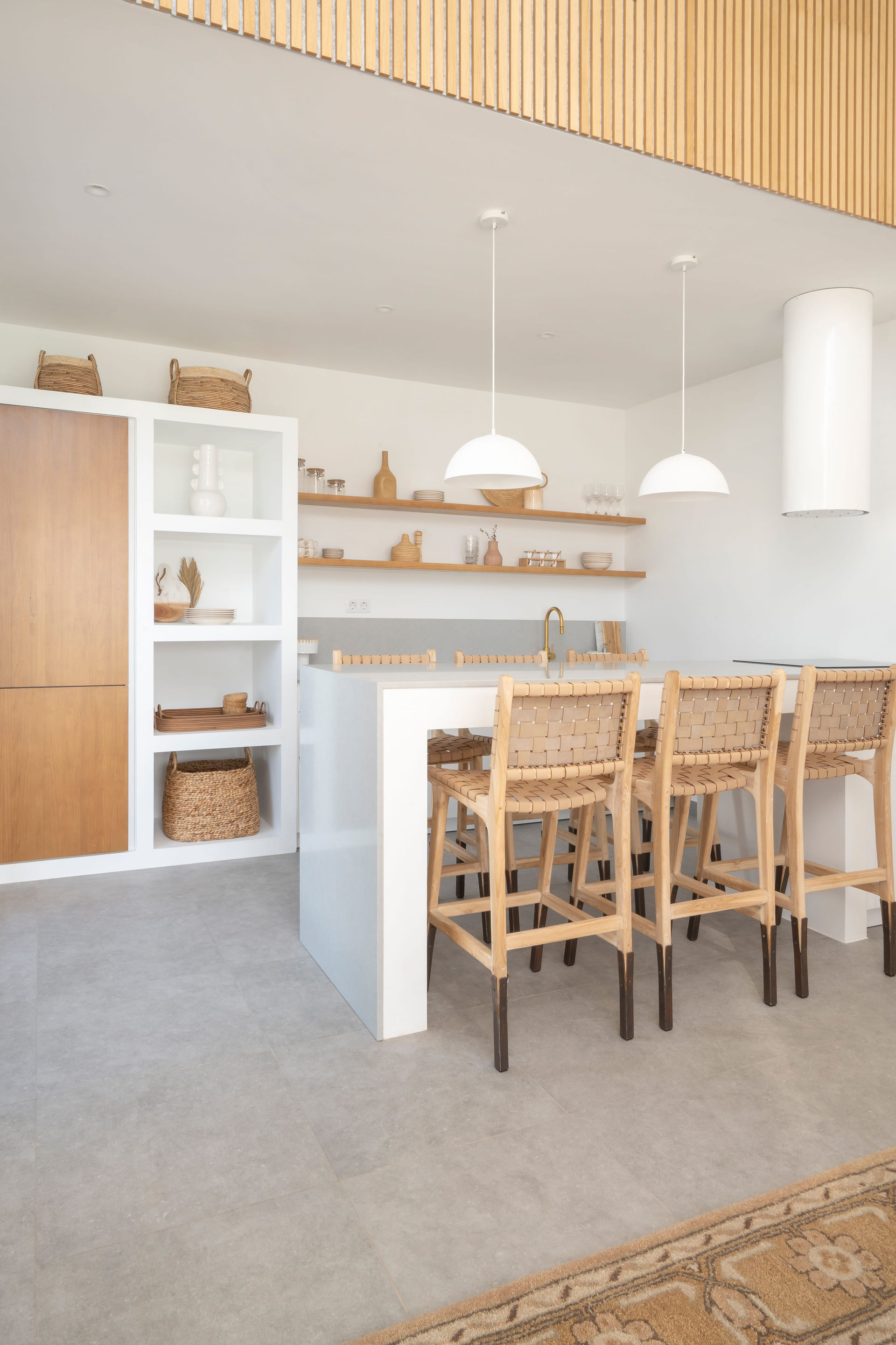 Kitchen Design in Fuerteventura, kitchen island with wooden stools and mediterranean interior decoration. Villa with pool in La Capellania, Tamaragua, El Palmeral, Corralejo by interior designer Noogar.