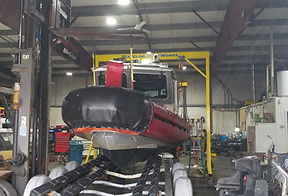 Commercial RIB work boat receiving outboard service inside the Stateline Boat Works marine service facility serving Southern Massachusetts and Rhode Island.