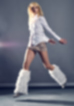 a fashion shoot, in which a stylish woman is in a studio with crisp front and back lighting, jumping in the air