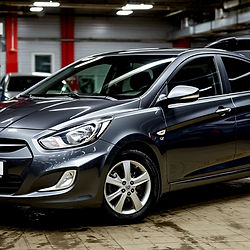 Автомобиль Kia Rio на подъемнике во время комплексной замены масла в автомате: слив старой ATF, чистка поддона, установка новой прокладки, смена фильтра и заключительная аппаратная прокачка. Изображение подчеркивает аккуратность мастеров и комплексный подход к обслуживанию АКПП A4CF1/A4CF2.